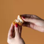 Manos abriendo una croqueta.