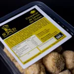 Paquete de croquetas sin gluten y fondo negro.