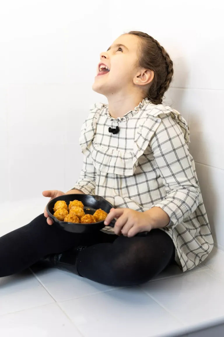 Niña feliz con sus croquetas.