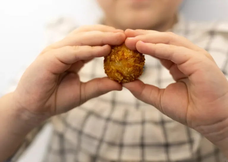 Mano de persona sosteniendo una croqueta
