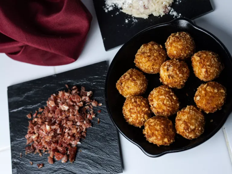 Bandeja de croquetas hechas y más comida.